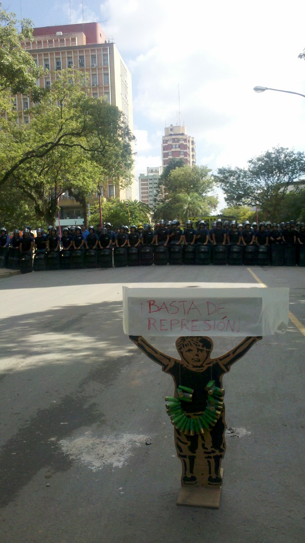 Muñeco con un collar realizado con los cartuchos usados por la policía.
